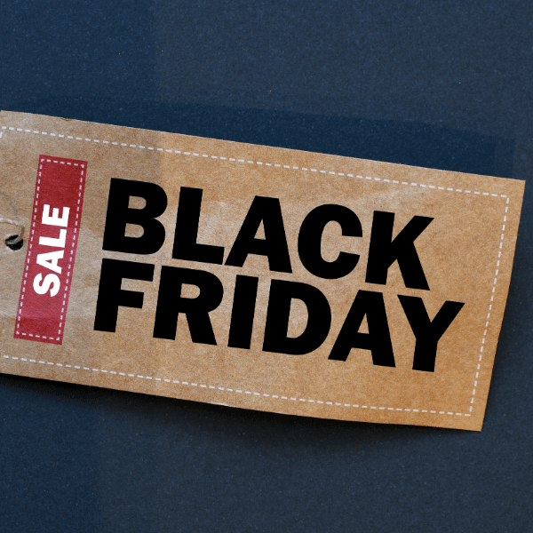 A foto mostra uma etiqueta em papel craft com a palavra em inglês "Sale" escrito em vermelho e "Black Friday" escrito em preto.